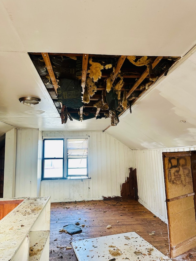 misc room featuring dark hardwood / wood-style floors, vaulted ceiling, and wood walls