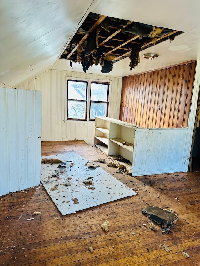 bonus room with wood walls, dark hardwood / wood-style floors, and lofted ceiling