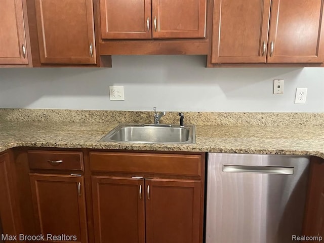 kitchen with dishwasher, light stone counters, and sink