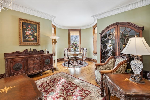 sitting room with crown molding and wood-type flooring