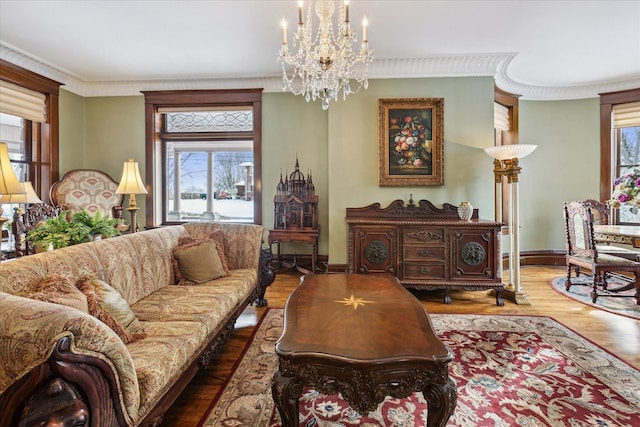 living room featuring hardwood / wood-style flooring, a notable chandelier, and crown molding