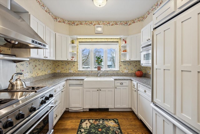 kitchen featuring high end stove, white cabinets, dark hardwood / wood-style flooring, and wall chimney exhaust hood