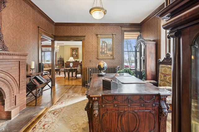 home office featuring a fireplace, wood-type flooring, radiator heating unit, and ornamental molding