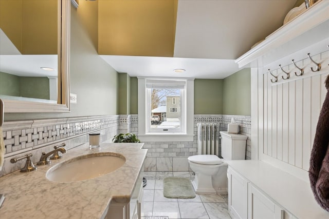 bathroom featuring radiator heating unit, vanity, and toilet