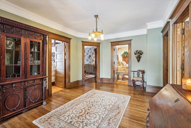 foyer entrance with a chandelier, hardwood / wood-style flooring, and ornamental molding