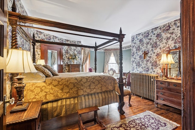 bedroom with hardwood / wood-style floors, crown molding, and radiator