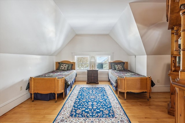 bedroom with light wood-type flooring and lofted ceiling