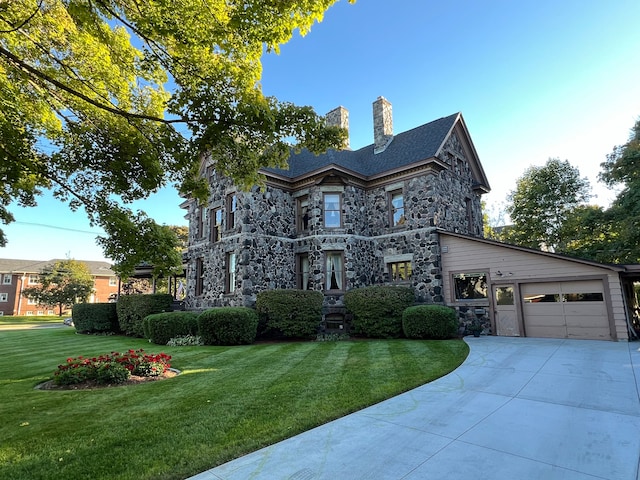 view of front of property featuring a garage and a front lawn