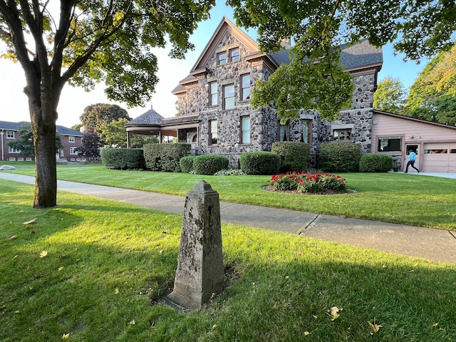 view of front of house featuring a garage and a front lawn