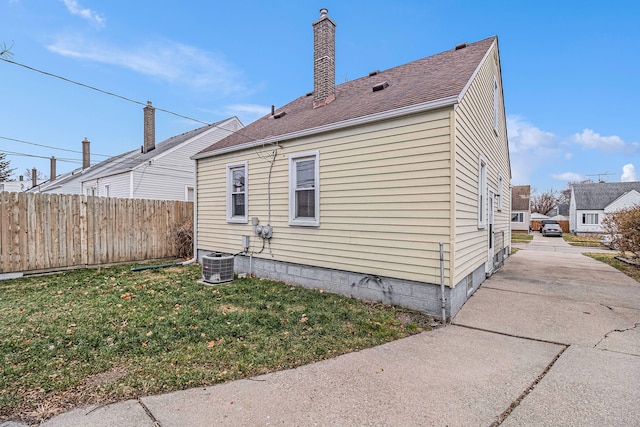 view of home's exterior featuring cooling unit and a lawn