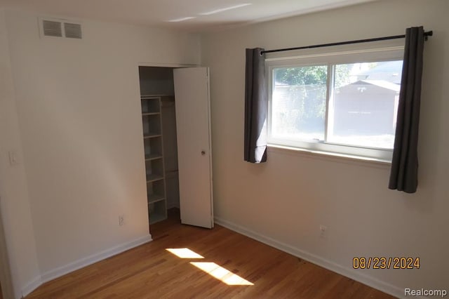 unfurnished bedroom with hardwood / wood-style flooring and a closet