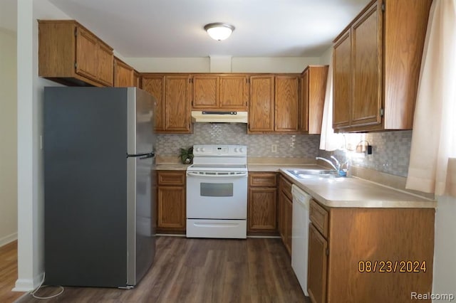 kitchen with tasteful backsplash, white appliances, sink, and dark wood-type flooring