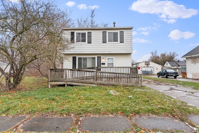 view of front facade with a front yard and a wooden deck