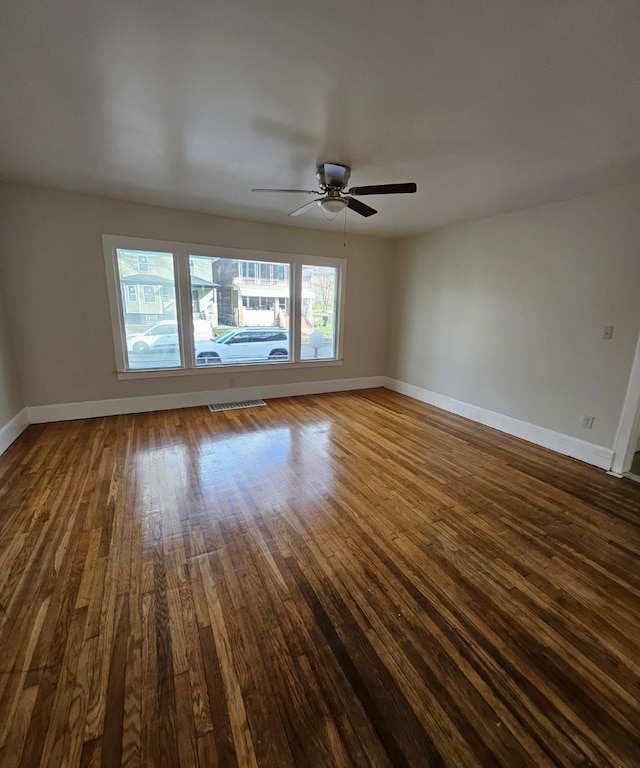 spare room featuring hardwood / wood-style floors, ceiling fan, and a healthy amount of sunlight