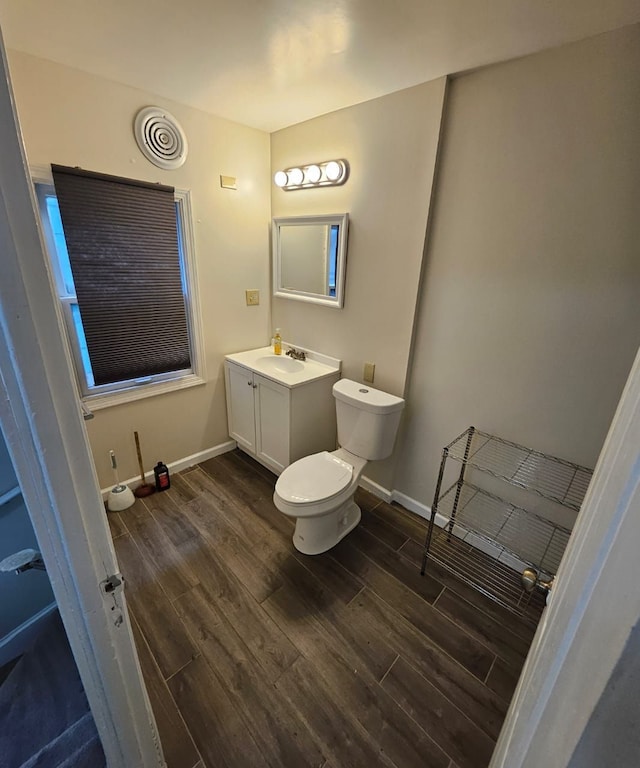 bathroom with toilet, vanity, and hardwood / wood-style flooring