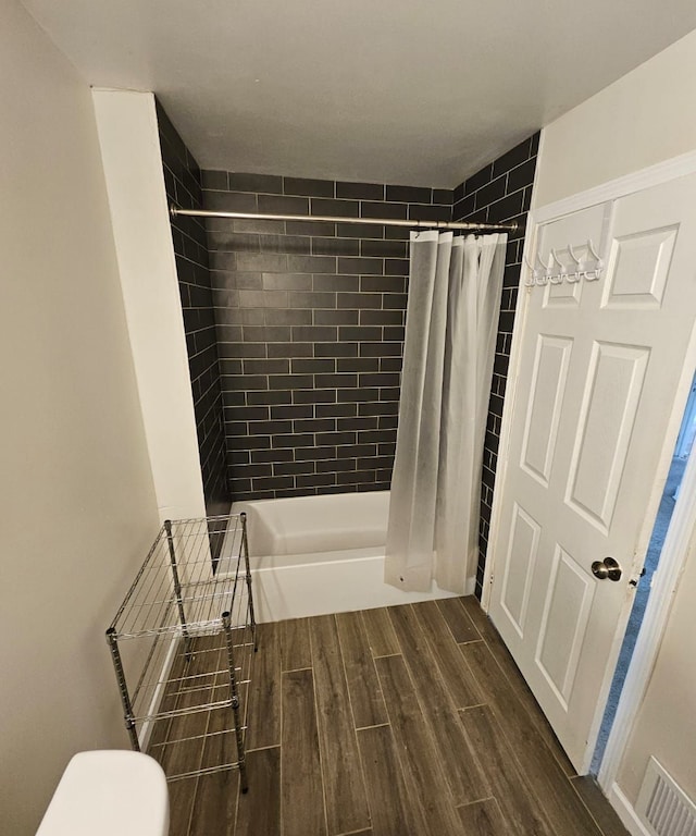 bathroom featuring hardwood / wood-style floors and shower / bath combination with curtain