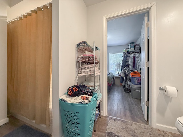 interior space with hardwood / wood-style floors and toilet