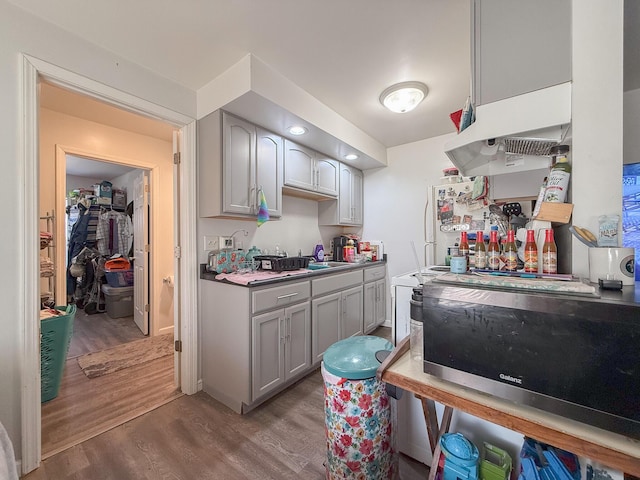 kitchen with gray cabinets, light hardwood / wood-style floors, and white refrigerator