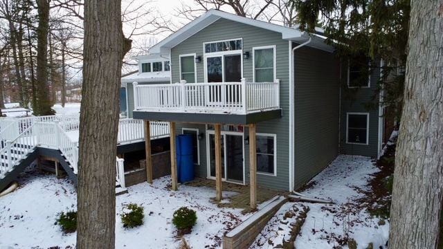 snow covered property with a wooden deck