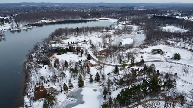 snowy aerial view featuring a water view