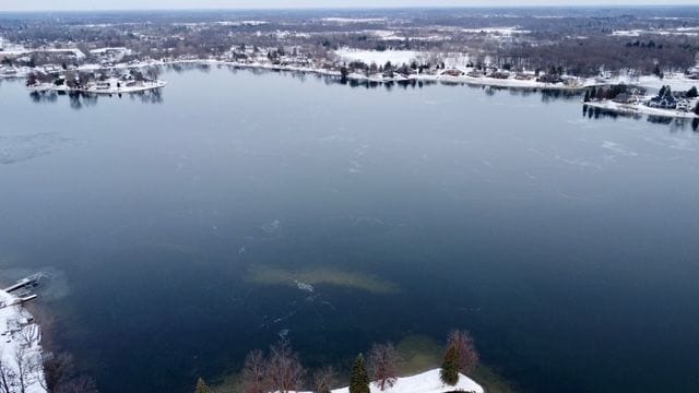 snowy aerial view with a water view