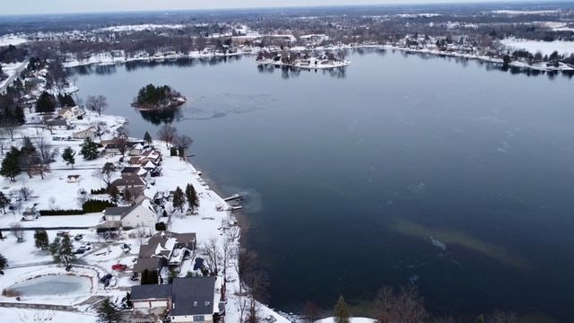 snowy aerial view with a water view