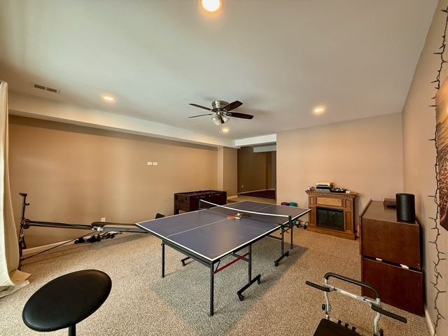 playroom with ceiling fan and light colored carpet