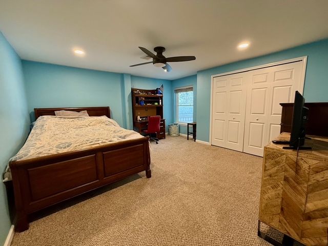 bedroom with ceiling fan, a closet, and light carpet