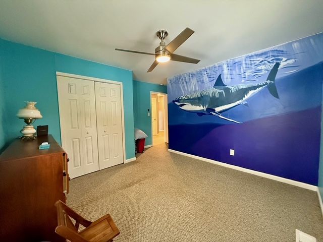 bedroom with ceiling fan, a closet, and carpet