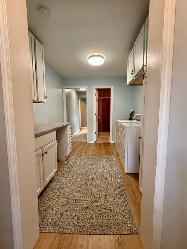 laundry area with cabinets, independent washer and dryer, and light hardwood / wood-style flooring