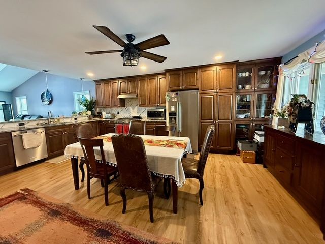 dining space featuring ceiling fan, light wood-type flooring, plenty of natural light, and sink