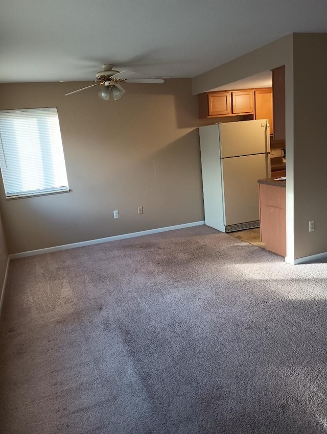 kitchen featuring ceiling fan, white refrigerator, and light colored carpet