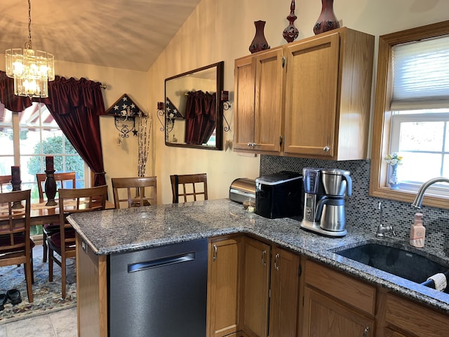 kitchen featuring decorative backsplash, dark stone counters, a healthy amount of sunlight, and sink