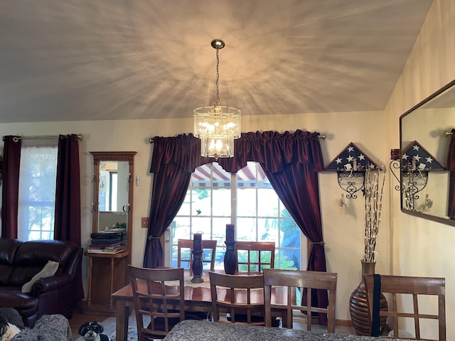 dining area with a chandelier and lofted ceiling