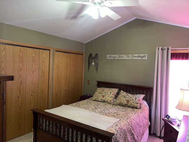 carpeted bedroom featuring multiple closets, ceiling fan, and lofted ceiling