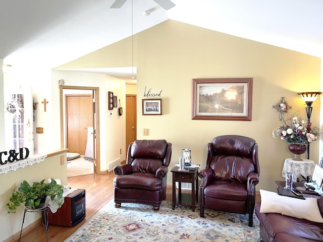 living room featuring wood-type flooring, vaulted ceiling, and ceiling fan