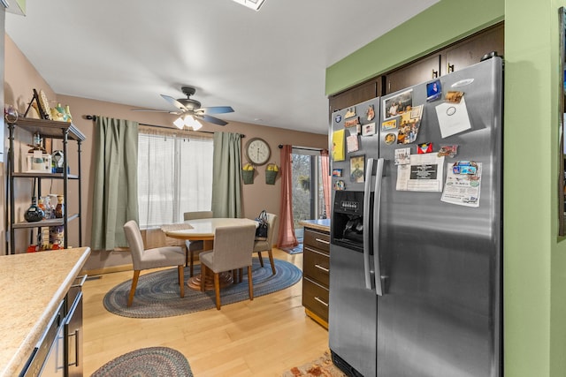 kitchen with stainless steel fridge with ice dispenser, light hardwood / wood-style floors, and ceiling fan