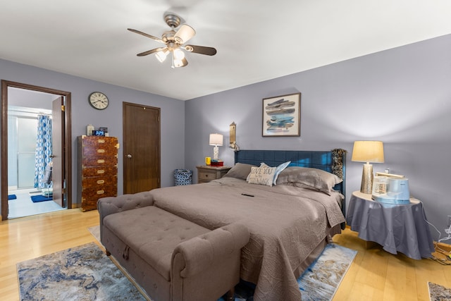 bedroom featuring light hardwood / wood-style floors, ensuite bath, and ceiling fan