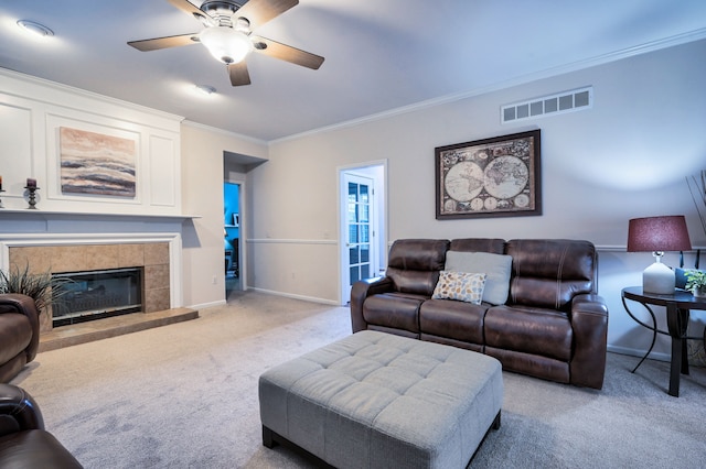 carpeted living room featuring ceiling fan, a fireplace, and ornamental molding