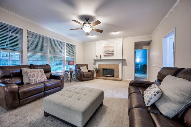 carpeted living room with a fireplace, ceiling fan, and ornamental molding