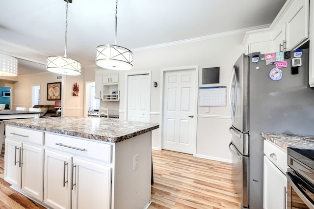 kitchen featuring hanging light fixtures, a kitchen island, crown molding, light hardwood / wood-style floors, and white cabinets