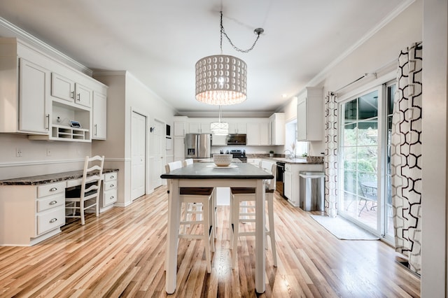 kitchen with stainless steel appliances, crown molding, decorative light fixtures, white cabinets, and light wood-type flooring