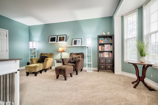 living area featuring light carpet and a healthy amount of sunlight