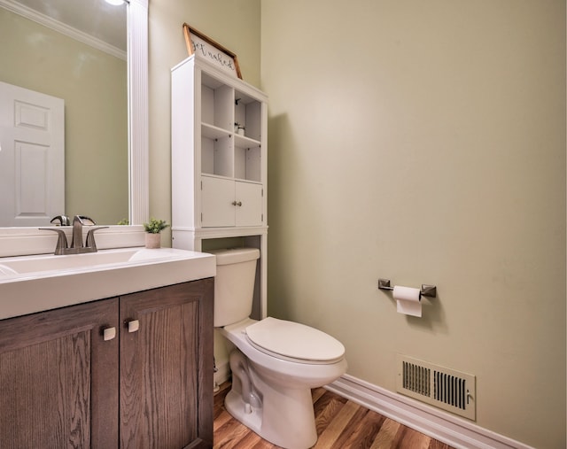 bathroom featuring crown molding, toilet, vanity, and hardwood / wood-style flooring