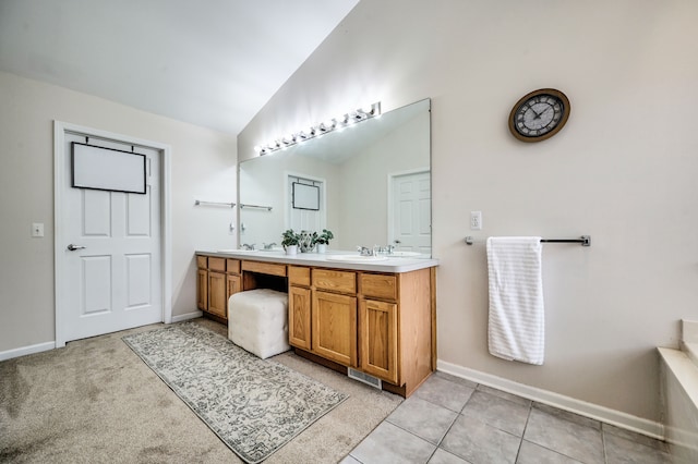 bathroom featuring tile patterned flooring, vanity, and vaulted ceiling