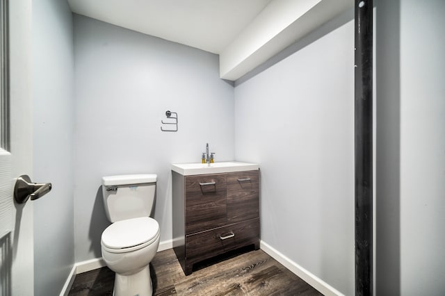 bathroom with hardwood / wood-style floors, vanity, and toilet