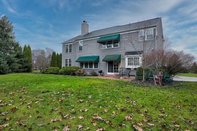 rear view of property featuring a patio area and a yard