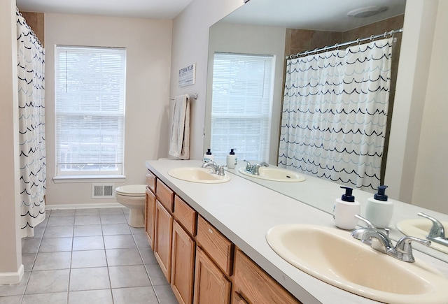 bathroom featuring toilet, vanity, tile patterned floors, and plenty of natural light