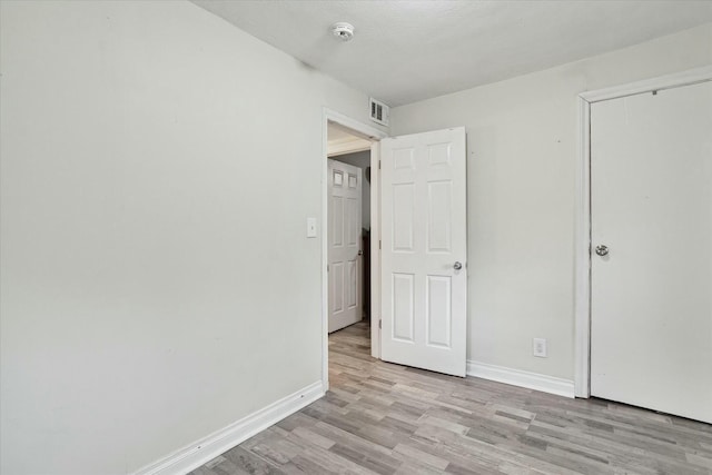 unfurnished bedroom featuring light hardwood / wood-style floors and a closet