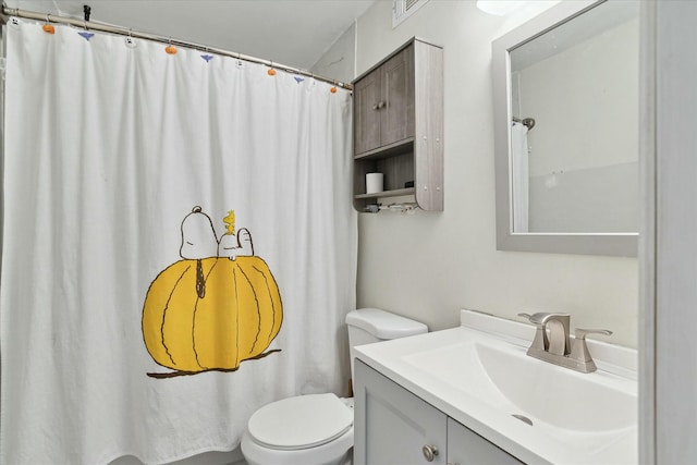 bathroom featuring walk in shower, vanity, and toilet